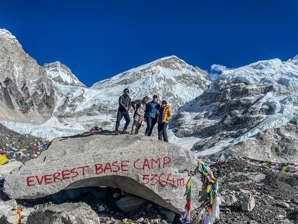 A group of people at the Everest Base Camp with snowy peaks in the background.