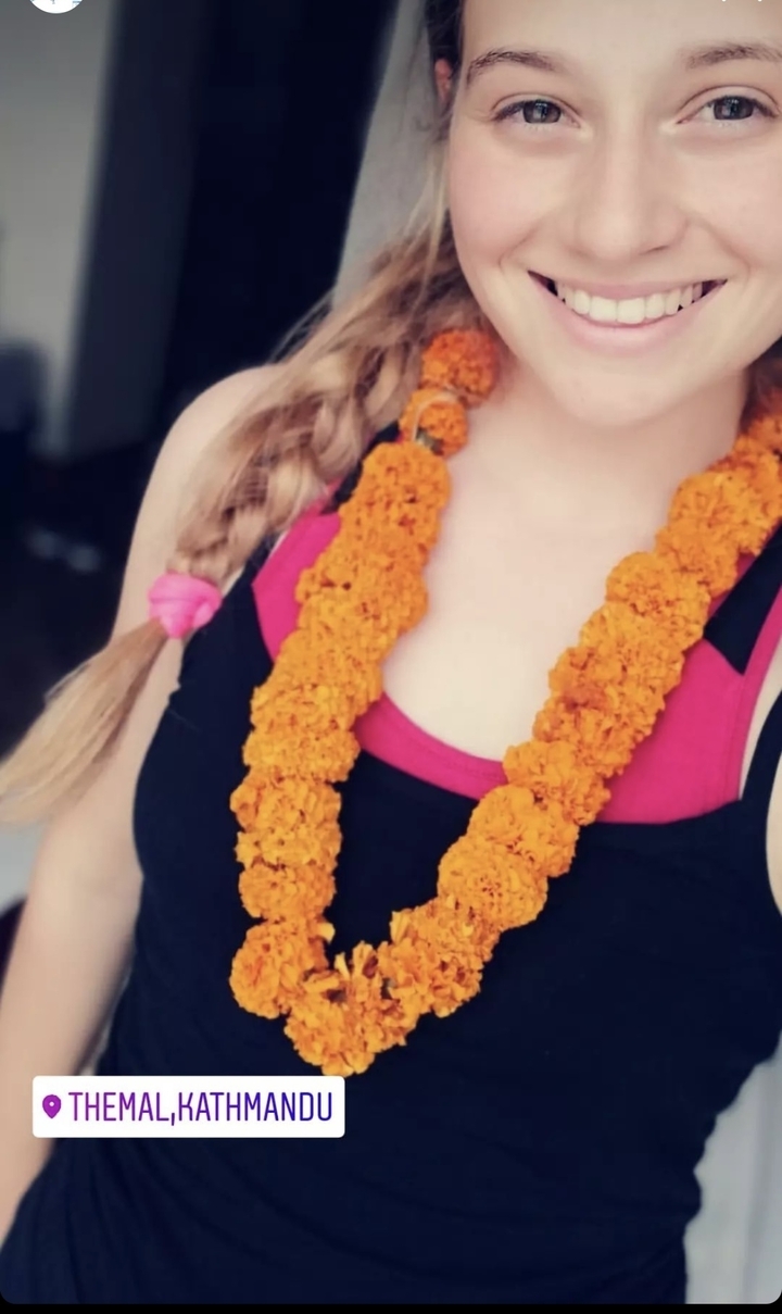 Close-up of person wearing a traditional marigold garland.