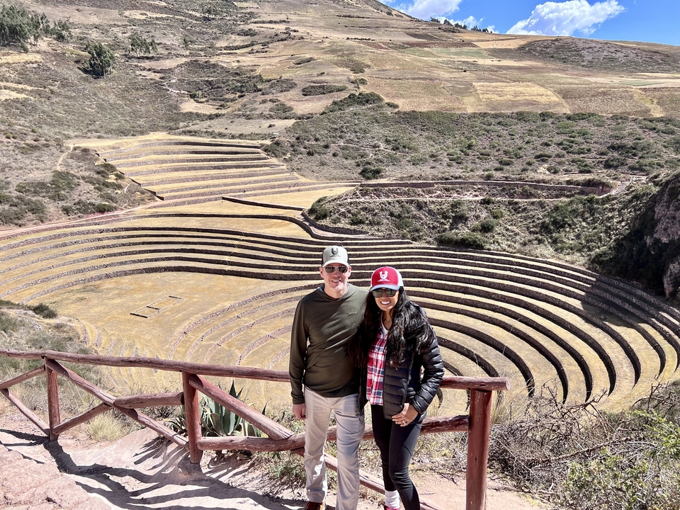 Couple posing at the Moray archaeological site with terraces in the background.