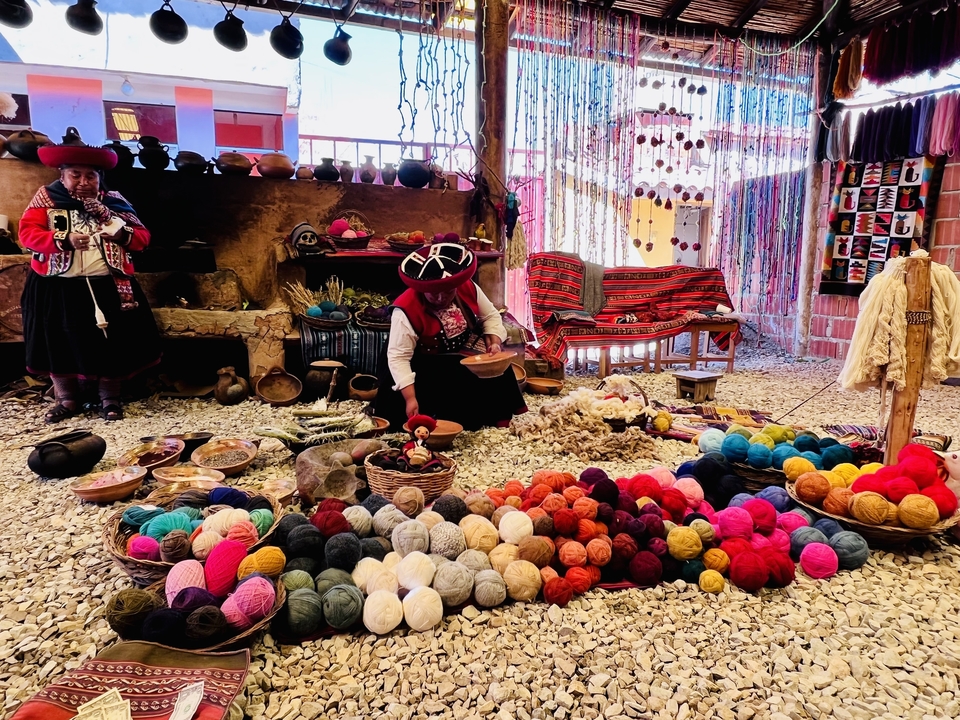 Women showcasing traditional Andean weaving and dyeing with colorful wool.