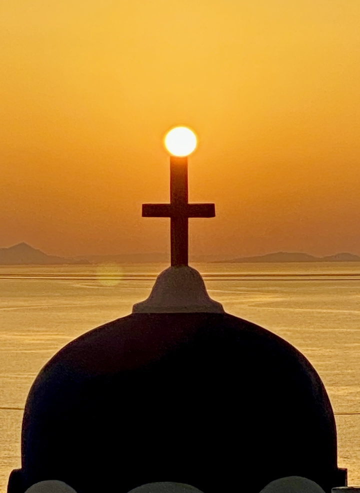 Silhouette d'une croix avec un coucher de soleil en arrière-plan.