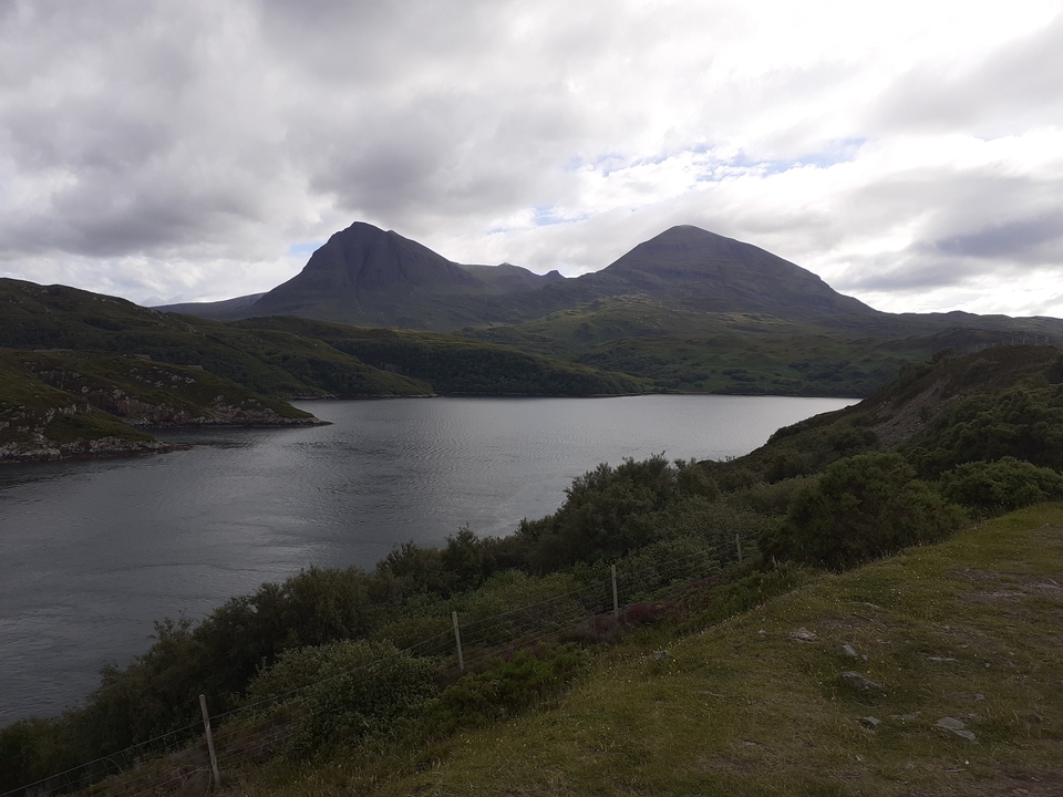 Mountainous landscape with a large lake in the foreground.