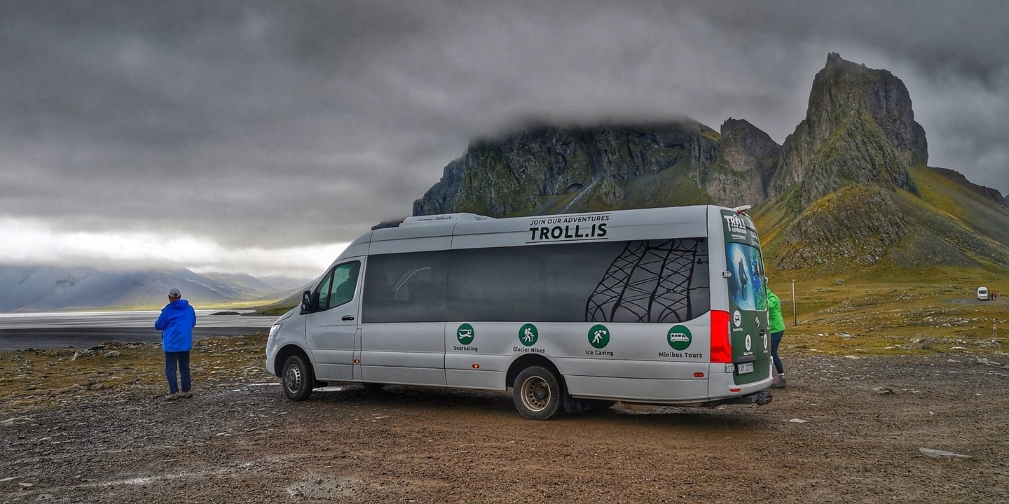 Autocar touristique avec des montagnes rocheuses et un ciel couvert