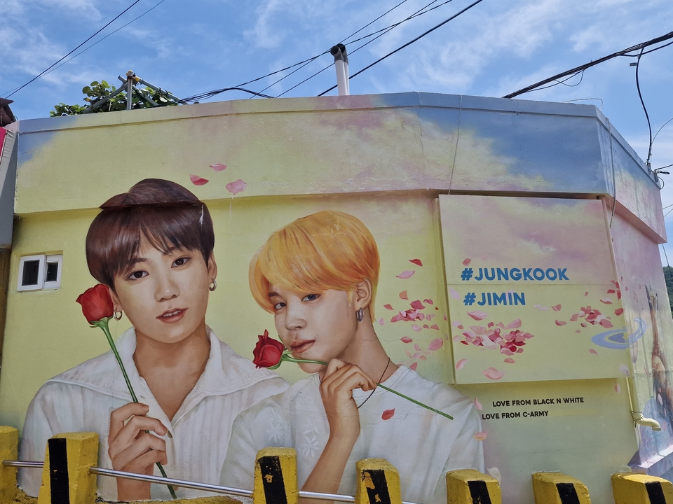 Wall mural featuring two figures and text hashtags.