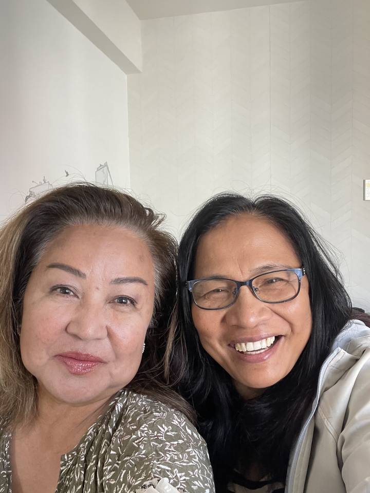 Two smiling people taking a selfie indoors.