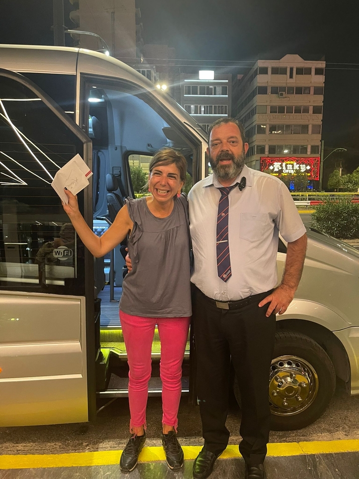 Deux personnes posant joyeusement devant un véhicule de tourisme.