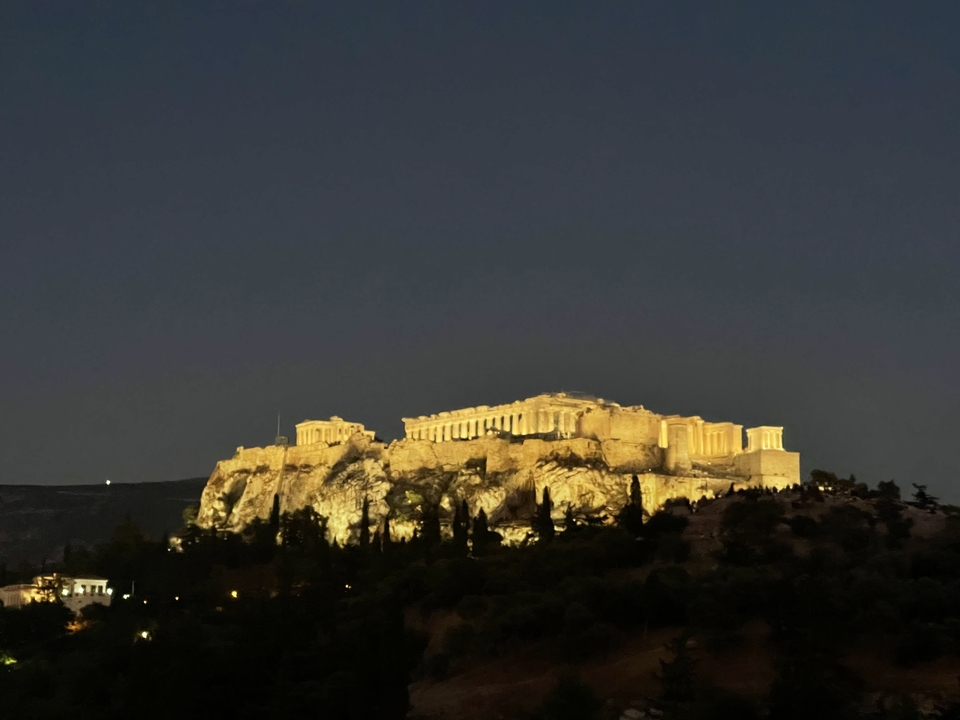 Vue nocturne de l'Acropole d'Athènes illuminée.