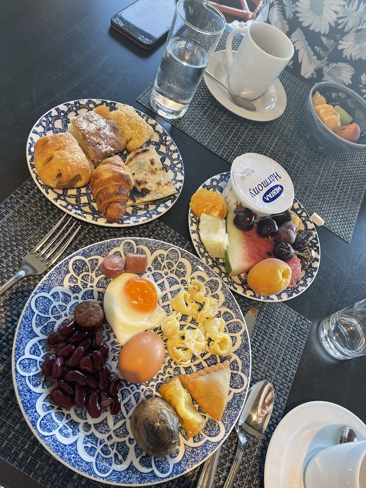 Articles de petit-déjeuner assortis dans des assiettes colorées avec un pot de yaourt.