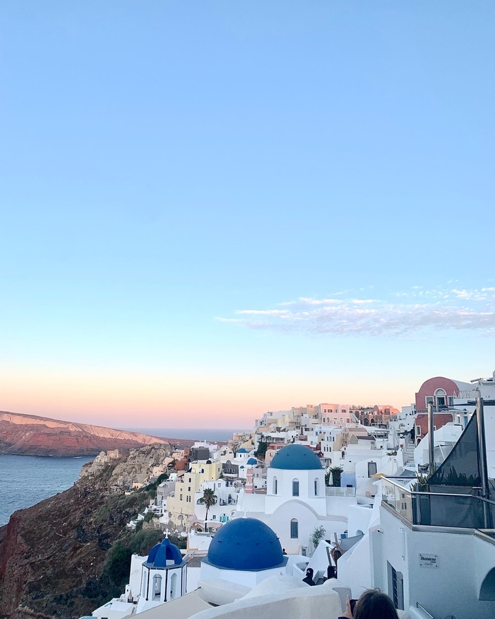 View of a town with pastel sky during sunset or sunrise over the sea.