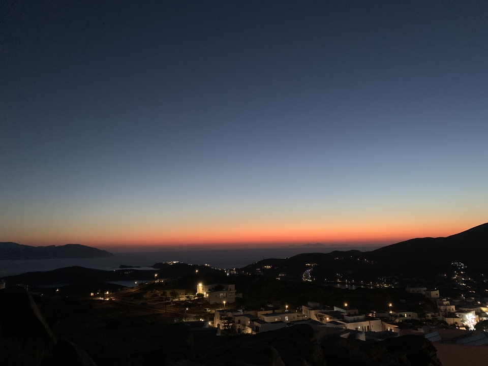 Sunset view over a seaside town with lights beginning to illuminate.