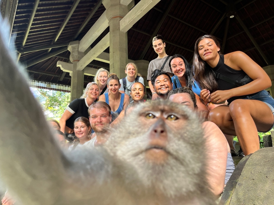 Group photo with a monkey at a temple site.