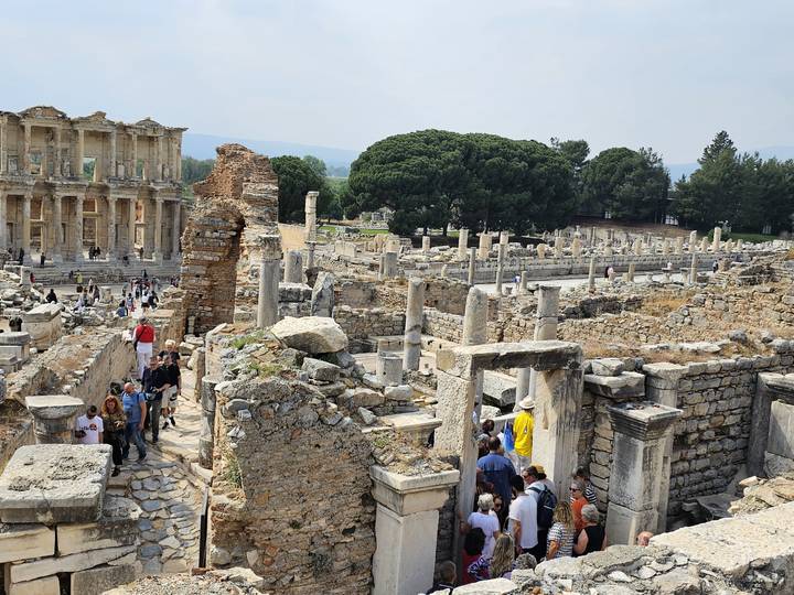 Ruines d'une ancienne cité avec des touristes se promenant alentour.