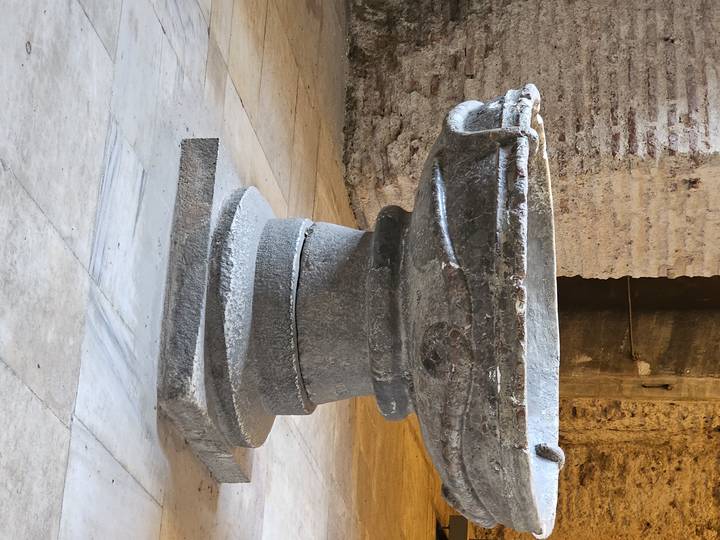 Piédestal en pierre dans un contexte archéologique.