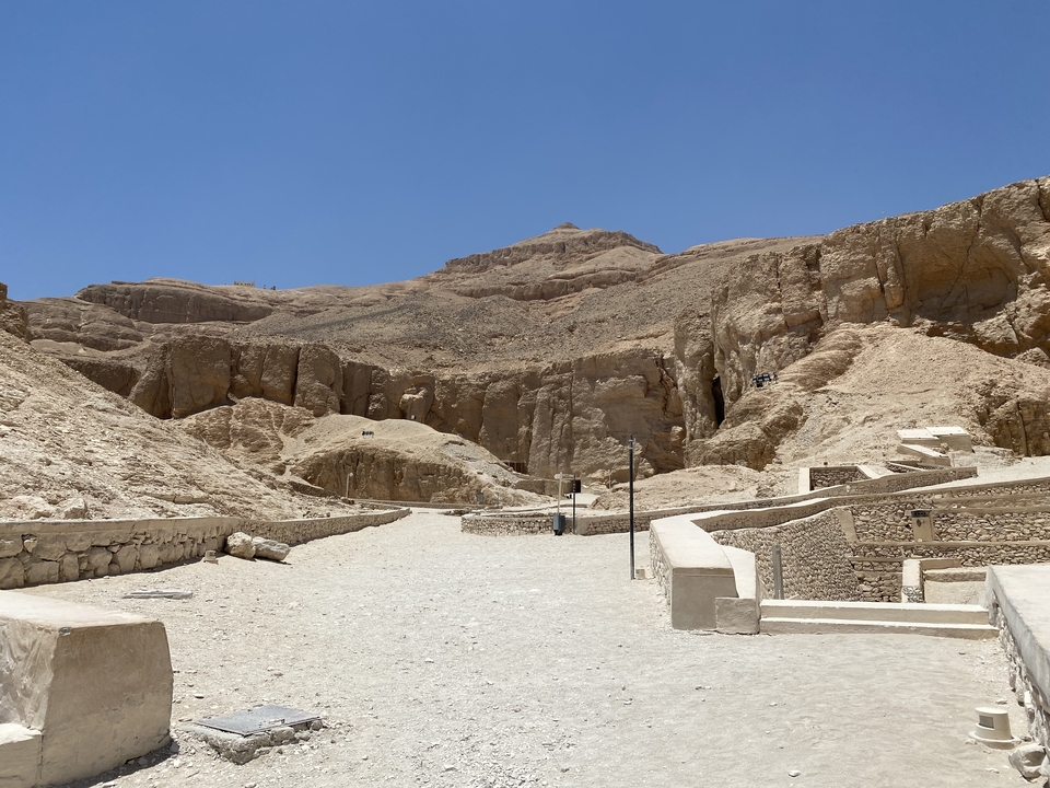 Un paysage désertique avec un terrain accidenté menant à des sites archéologiques.