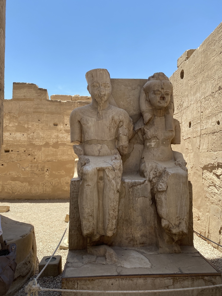 Statues de figures assises sculptées dans la pierre dans un temple.