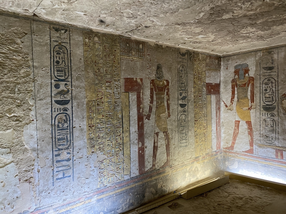 Gros plan d'art mural égyptien antique avec des figures colorées.