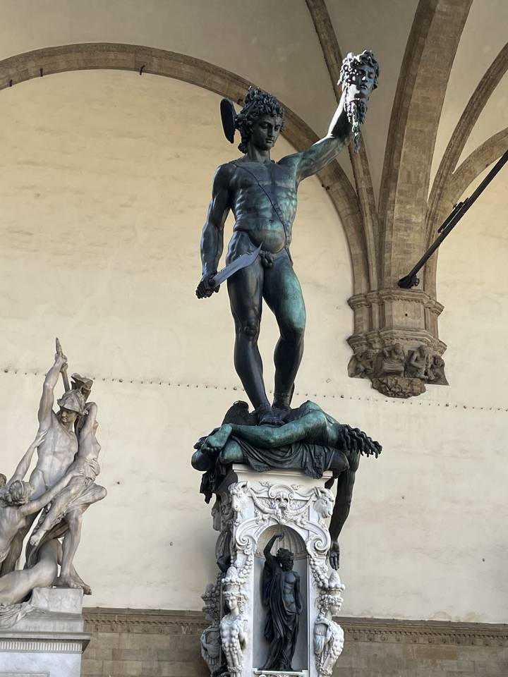 Statue dans un bâtiment historique recouvert d'œuvres d'art complexes.