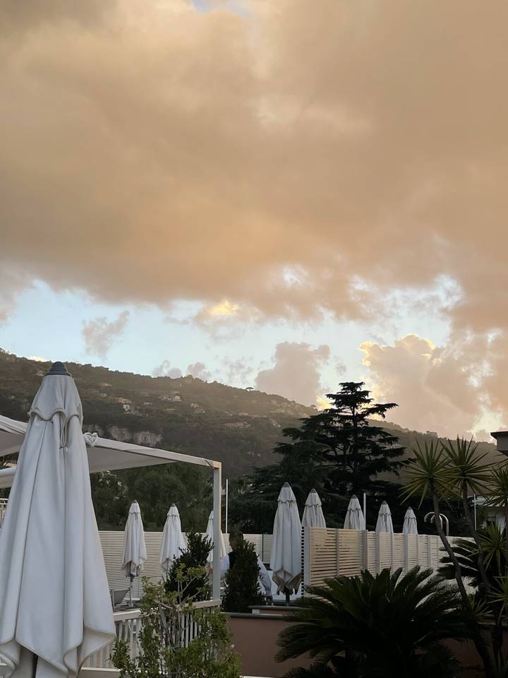 Des montagnes en arrière-plan avec un ciel rempli de nuages.