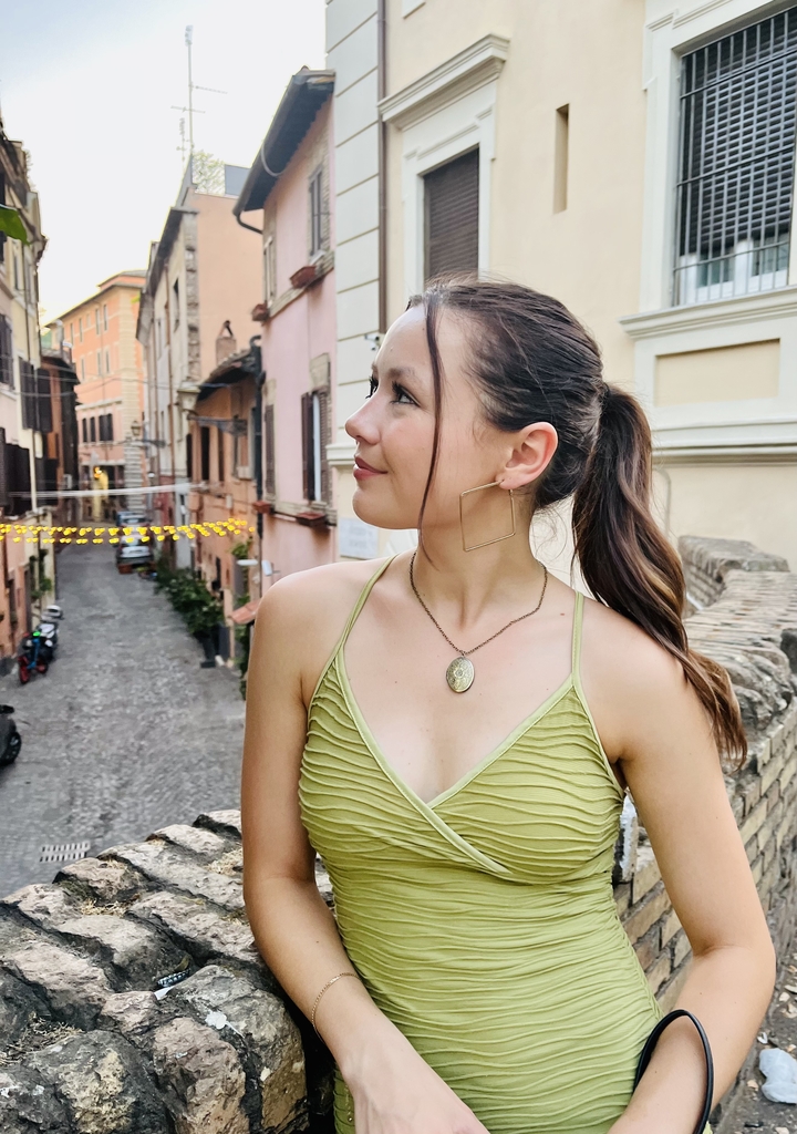 Woman on cobblestone street with decorative lights