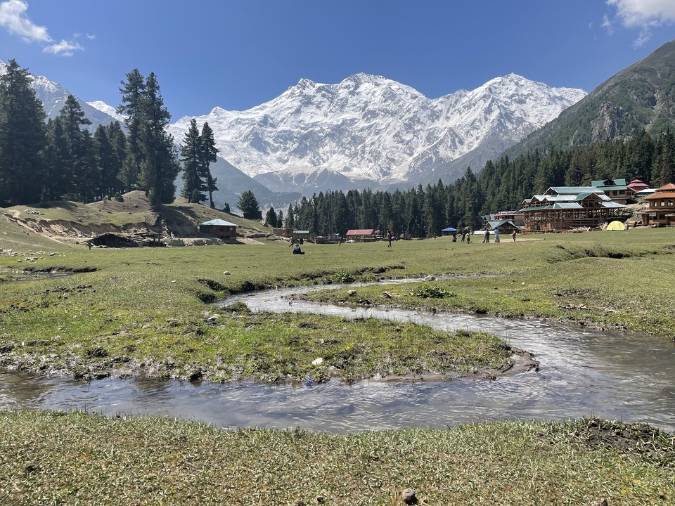 Scenic view of a valley with houses and snowy mountains.