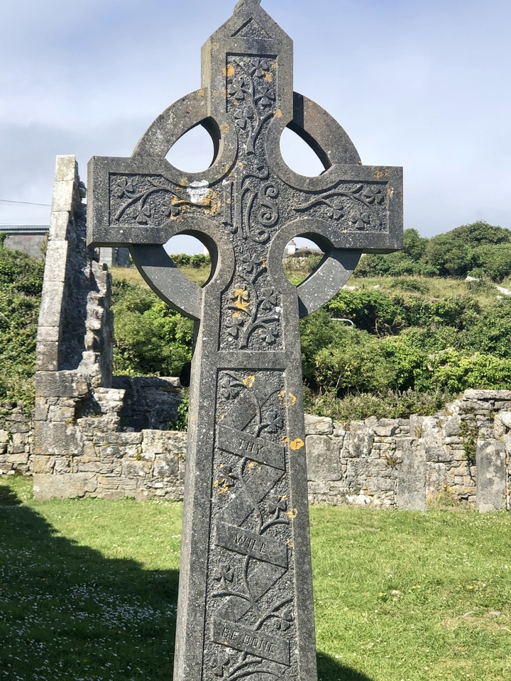 Detailed view of a Celtic cross in a graveyard.