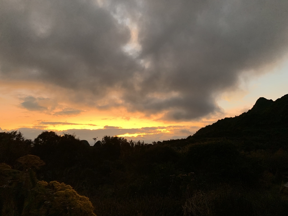 Stunning vibrant sunset behind mountain silhouette.