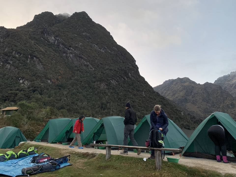 Campsite with green tents in a mountainous area.