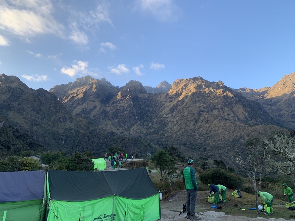 Campers and tents in a mountain setting during twilight.