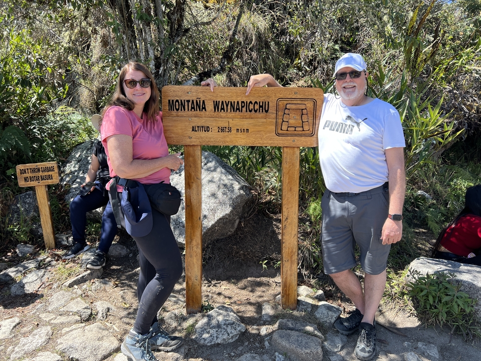 Tourists posing with a sign for Montaña Waynapicchu.