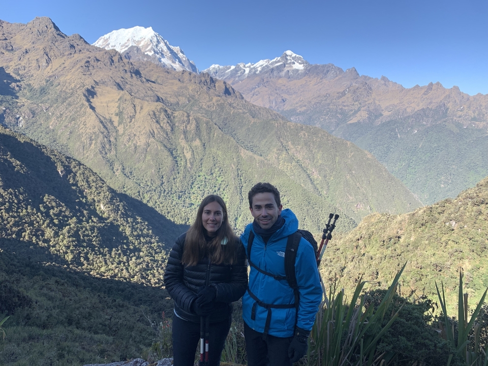 Couple posing in front of a mountainous landscape.