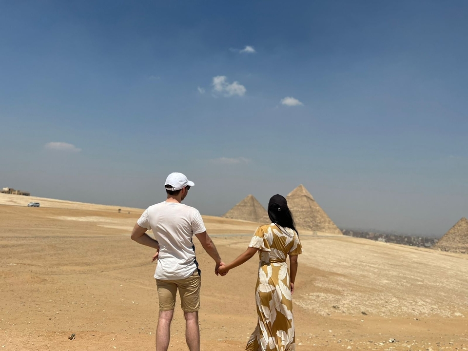 Couple holding hands and viewing the pyramids.