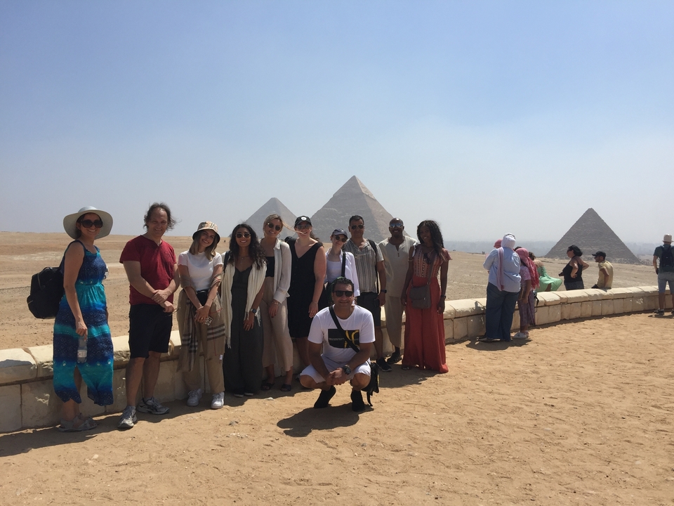 A group of people posing in front of the pyramids.