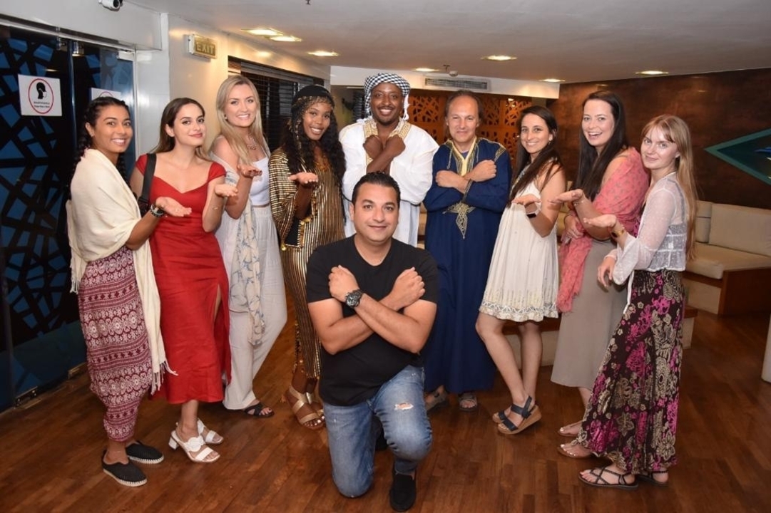 A group of people in traditional attire posing indoors.