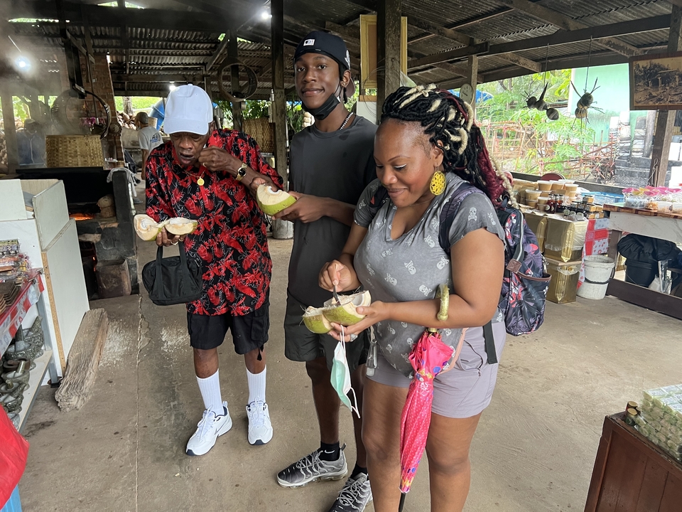 Menschen genießen Kokosnüsse auf einem Markt.