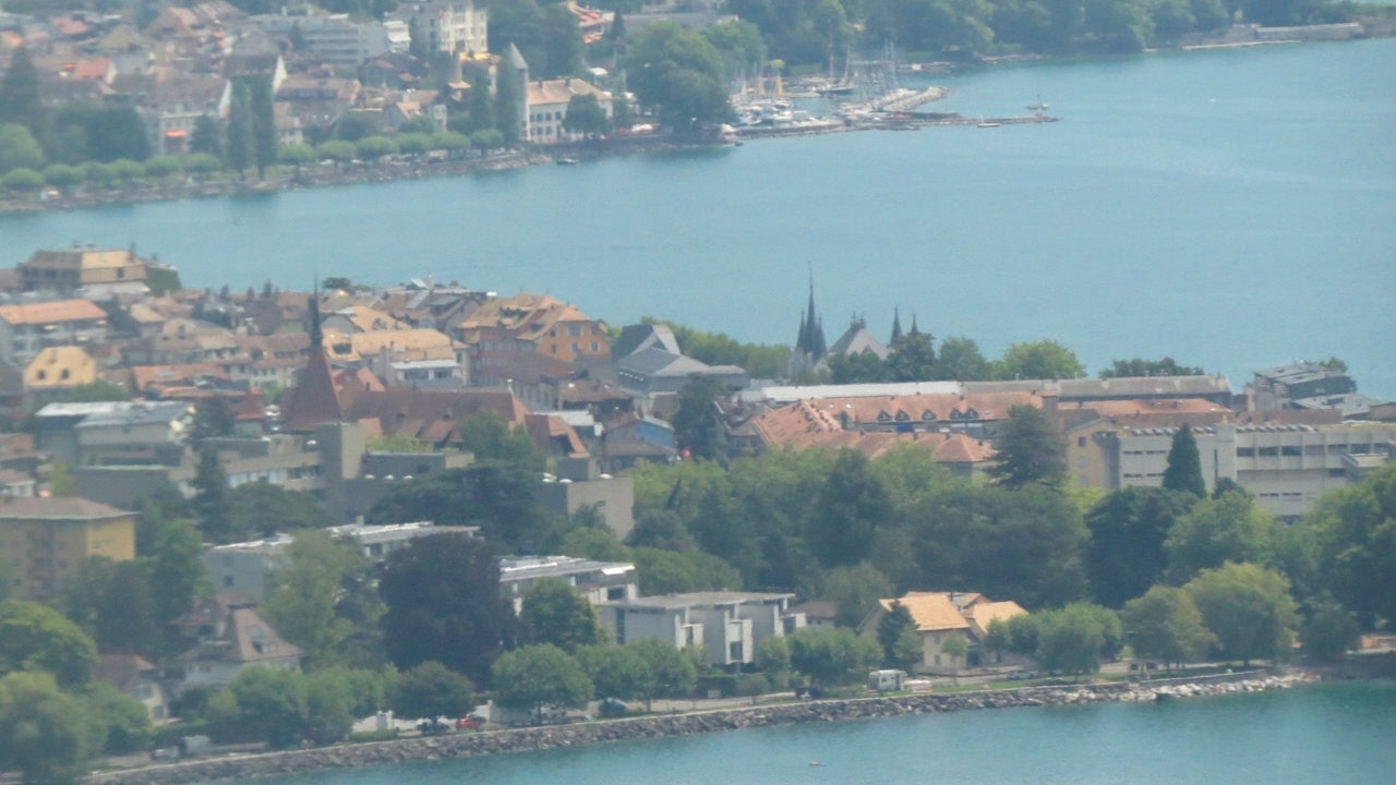 Aerial view of a town with rooftops near a lake.