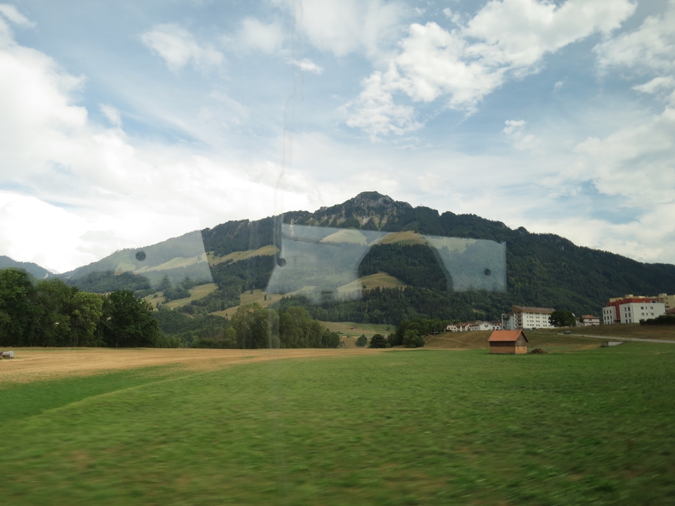 Hills and a mountain seen through a vehicle window