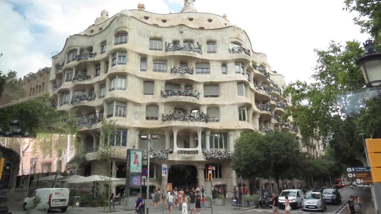People in front of a busy street with modernist architecture building.