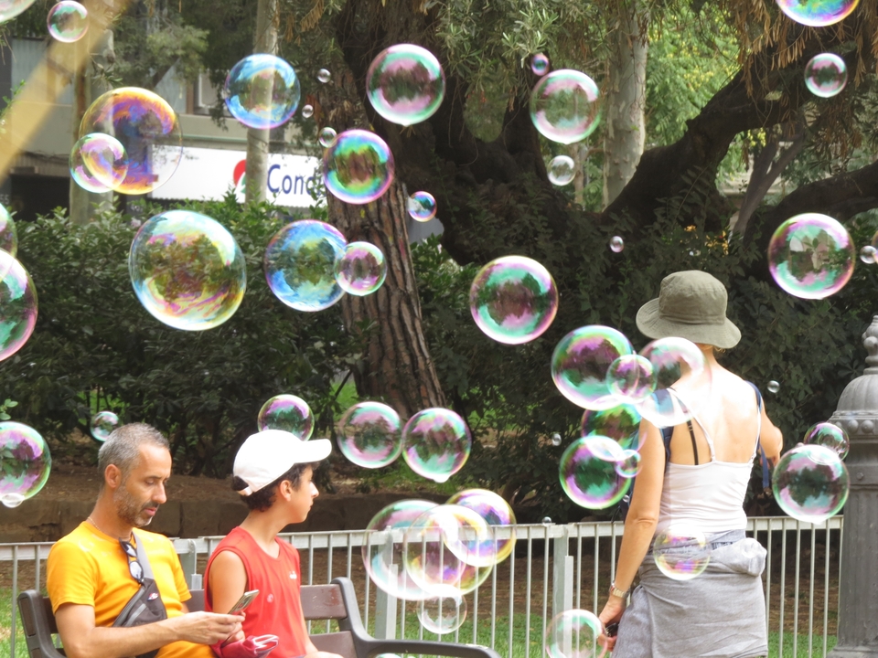 People surrounded by soap bubbles in a park