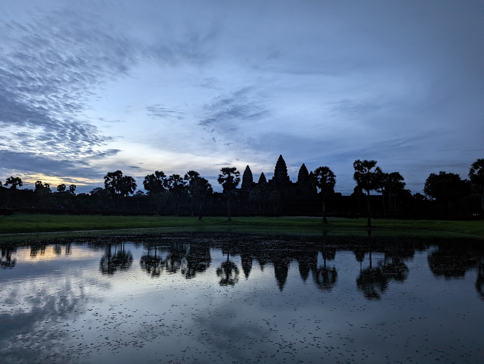 Silhouette of a temple with reflection in water at dusk.