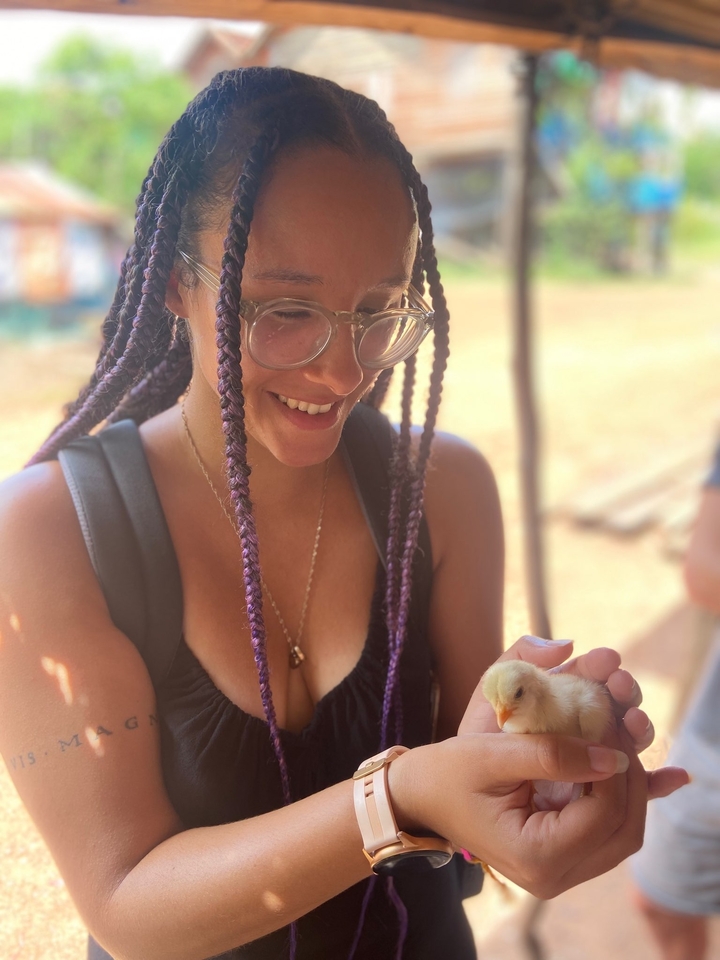 Close-up of a smiling woman holding a small object.