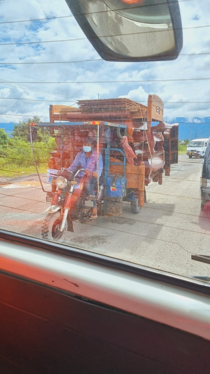 Motorcycle with a large load of furniture on the back.