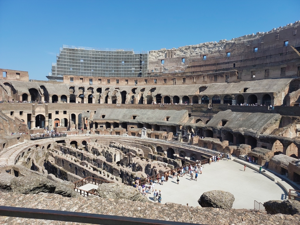 Interior view of the Colosseum with tourists exploring.