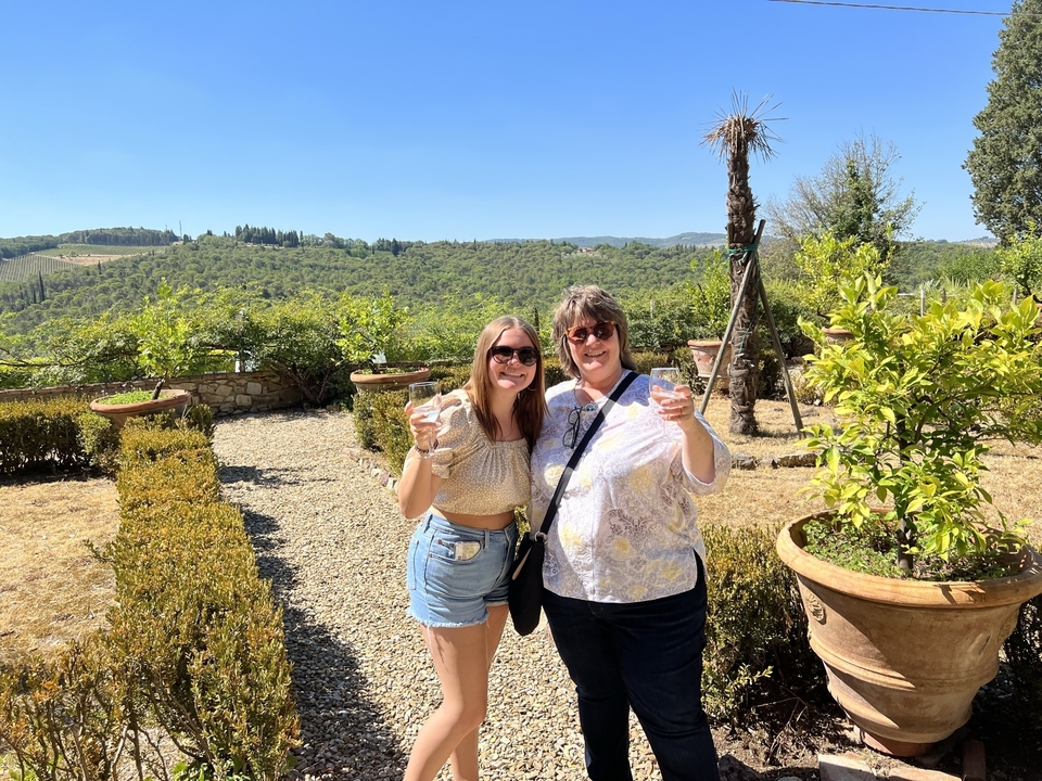 Two women enjoying drinks in a lush garden.