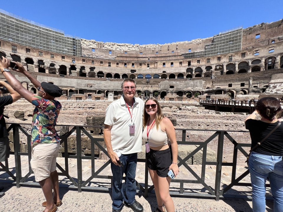 Interior view of the Colosseum with tourists posing.