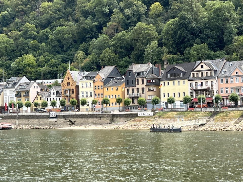 Colorful buildings alongside a river with a small ferry.