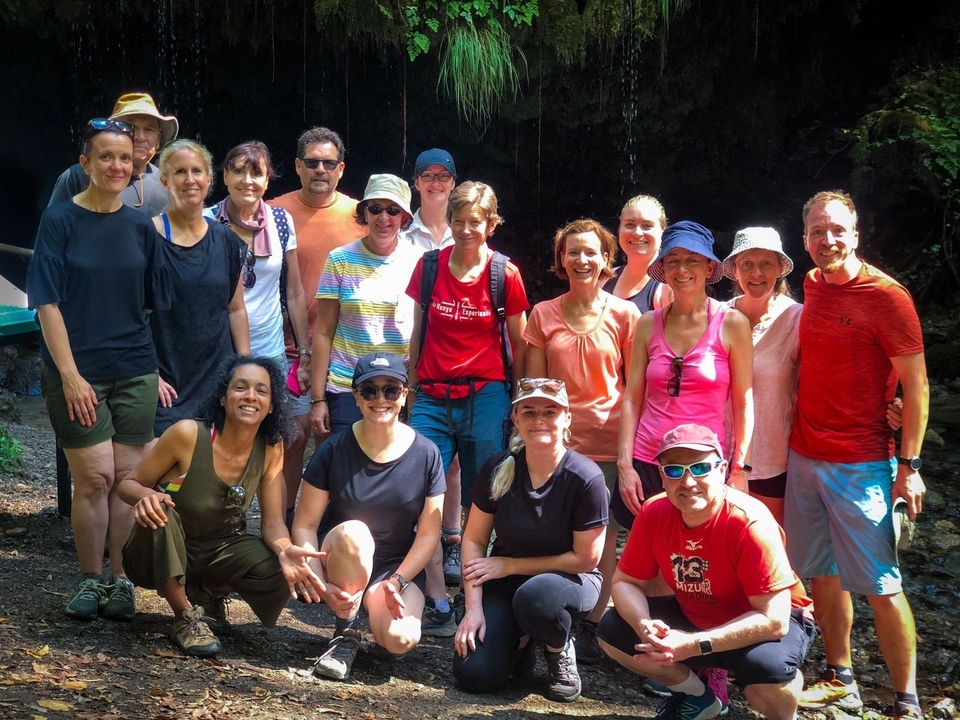 Outdoor group photo of people standing on a trail.