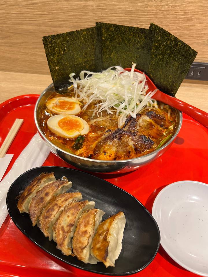 Repas japonais traditionnel avec des ramen et des boulettes.