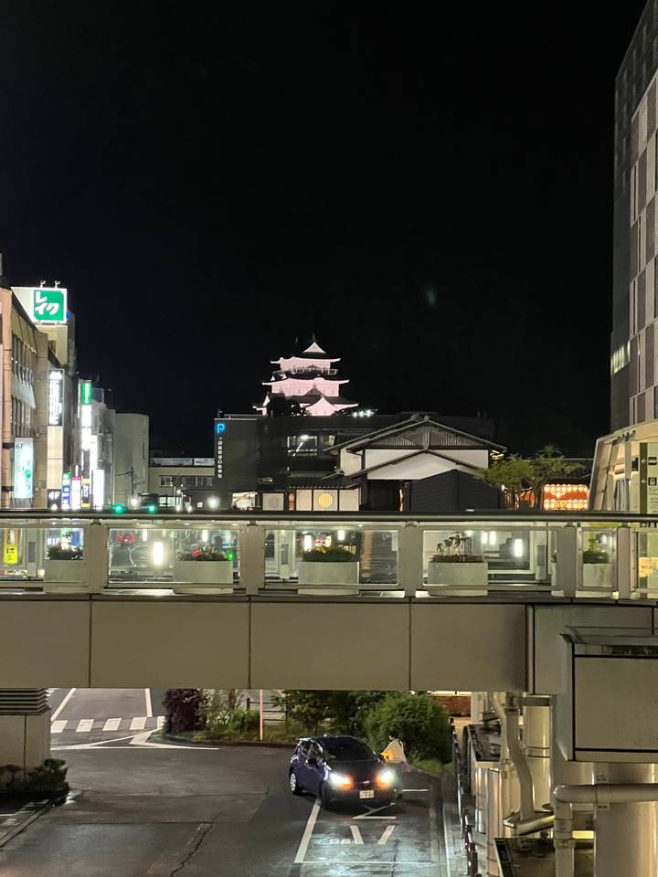 Vue nocturne d'un bâtiment ressemblant à un château et d'une rue.