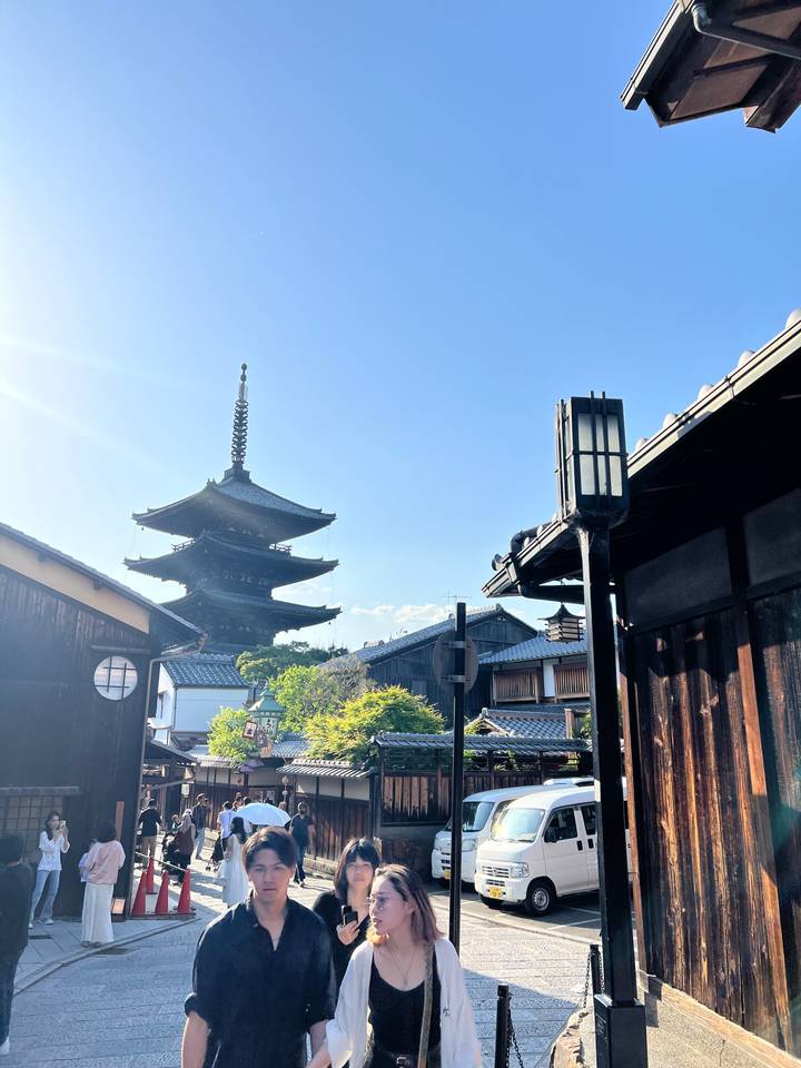 Des gens qui marchent près d'une pagode dans un quartier historique.