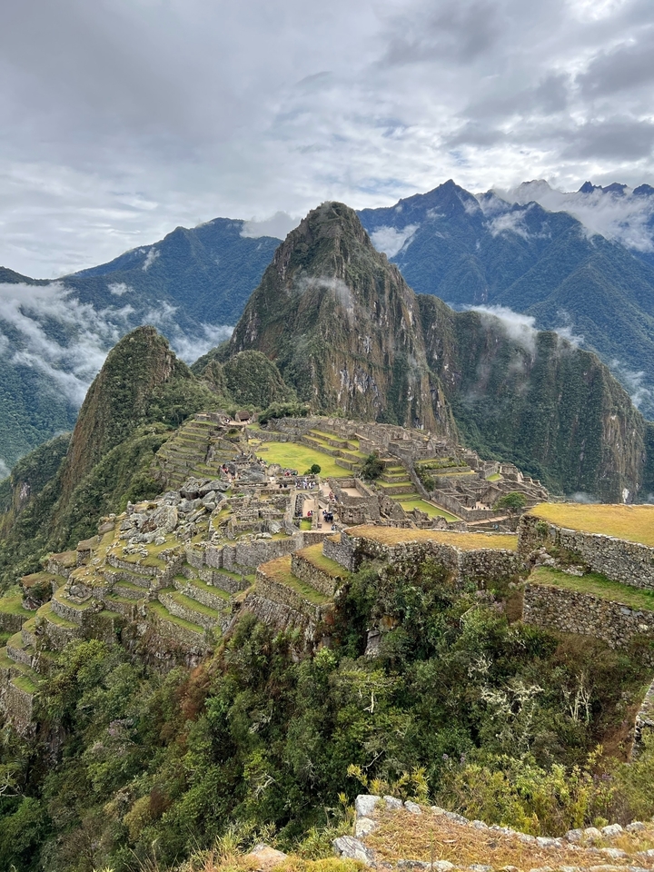 View of Machu Picchu with terraced stone ruins and mountains in the background.